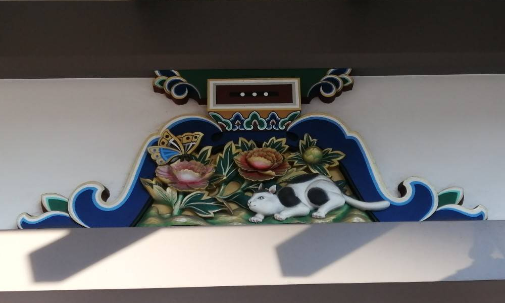 蝶々と遊びたそうにしている猫ちゃんの彫り物写真